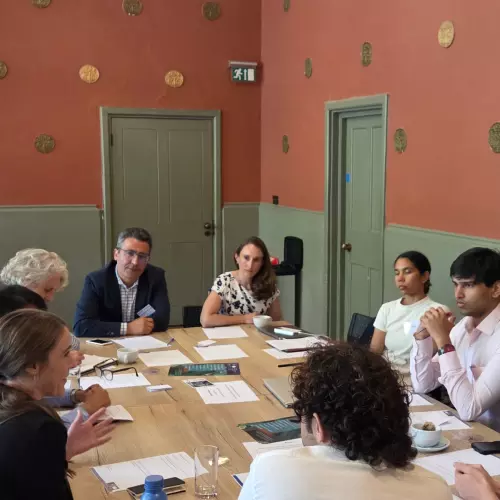 Delegates seated around a table during a group discussion