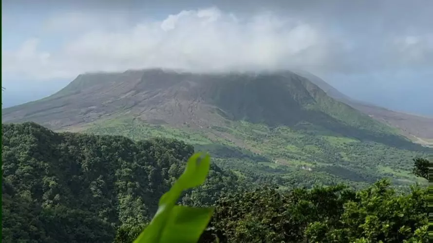 Tropical greenery framing Soufrière Hills Volcano in Montserrat in the background