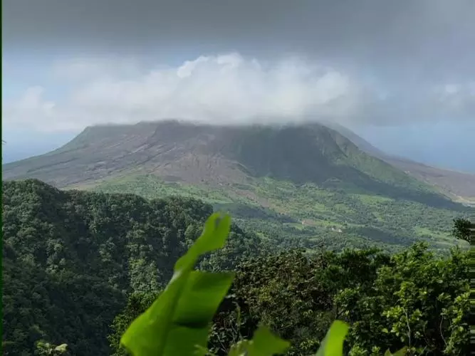 Tropical greenery framing Soufrière Hills Volcano in Montserrat in the background